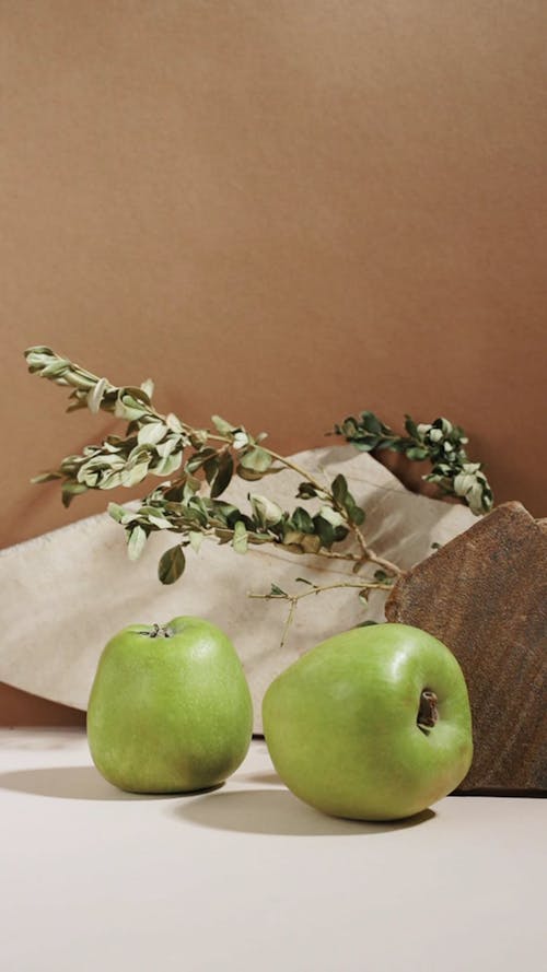 Green Apples Beside the Leaves and a Rock