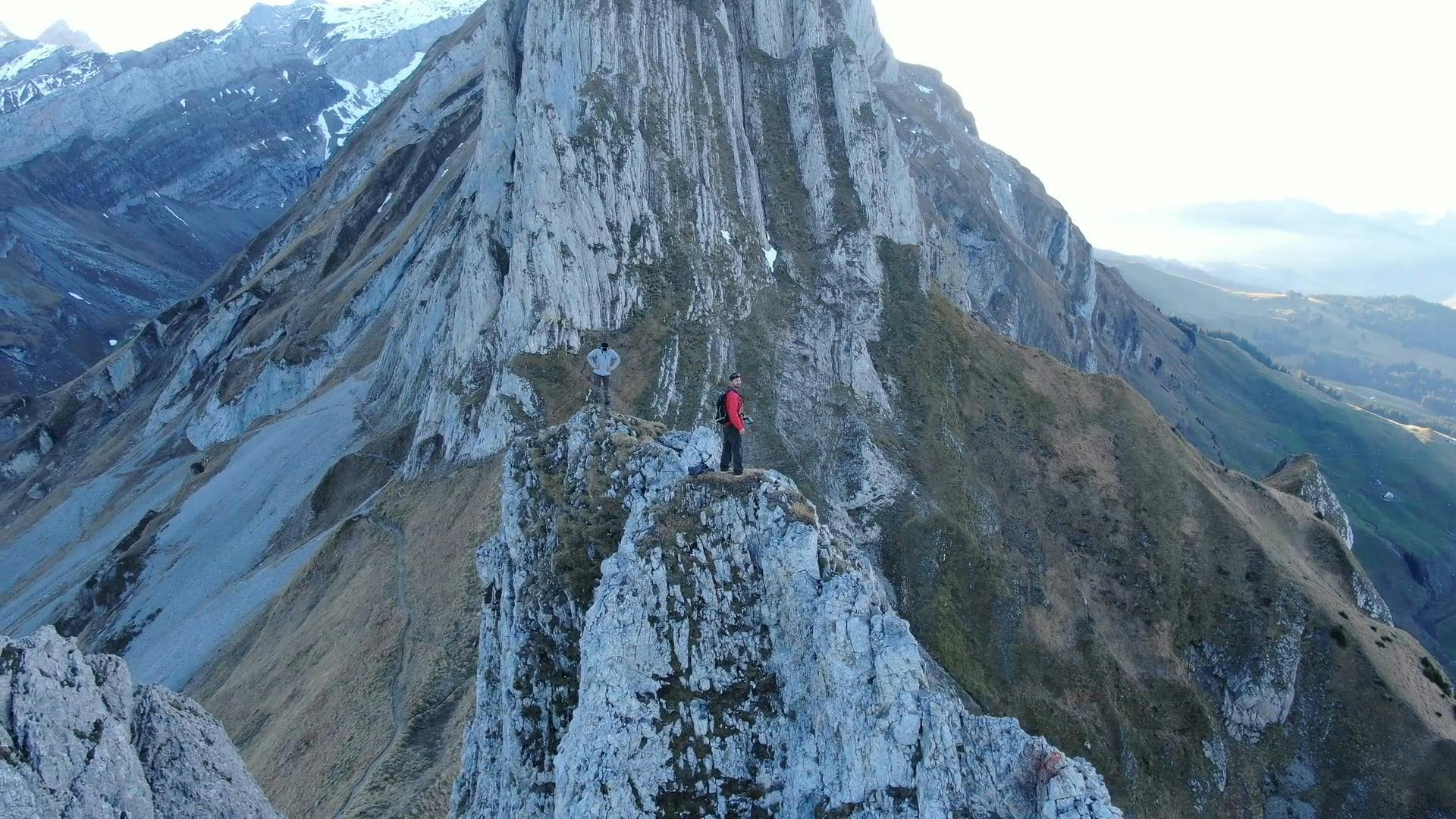 aerial-footage-of-men-standing-at-the-top-of-a-mountain-free-stock-video