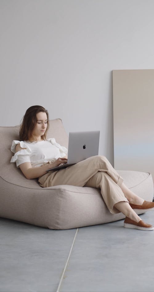 Woman on Couch Typing on Computer