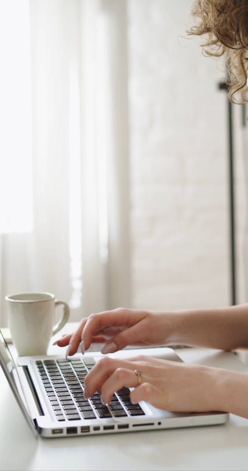 Woman Typing on Computer and Taking Notes