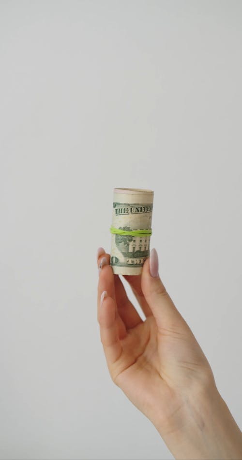 A Person Holding a Roll of Money