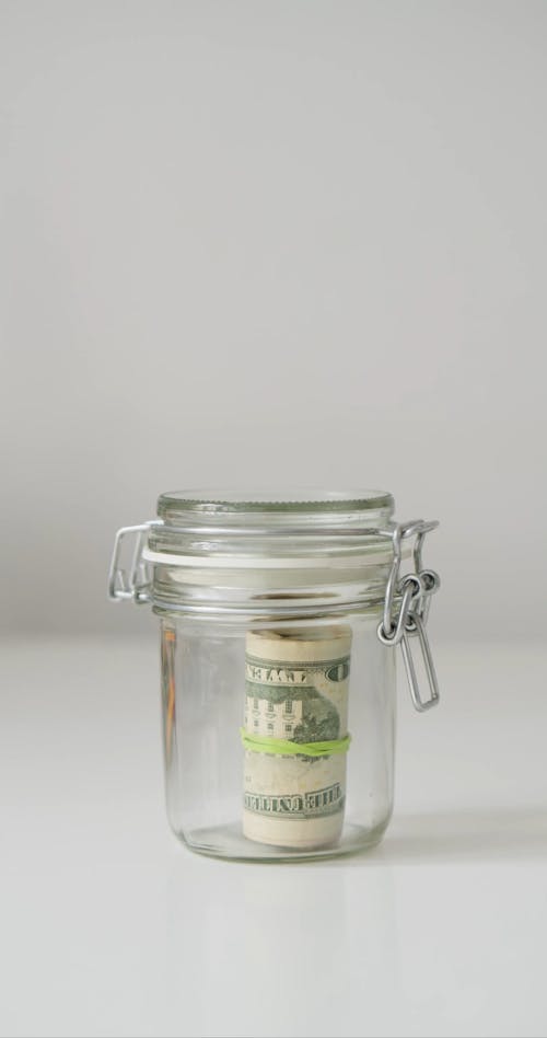 A Person Getting Money in a Jar