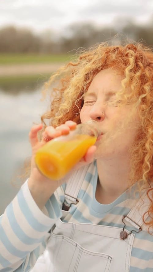 Woman Drinking from a Glass Bottle