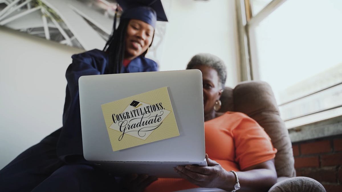 A Woman Wearing a Graduation Gown Holding a Graduation Cap and a ...