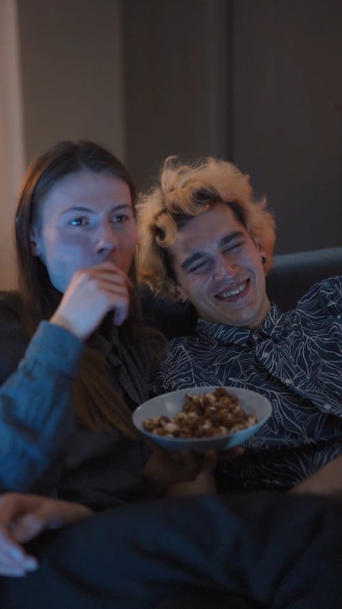 Couple Laughing while Watching Movie