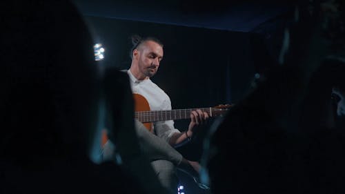 Artist Playing Guitar in Front of Audience