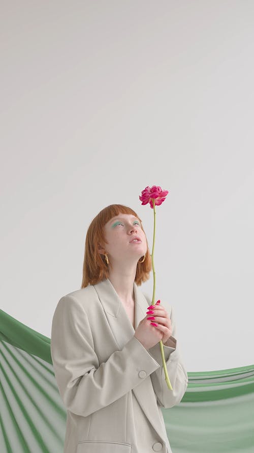A Woman Holding A Pink Flower