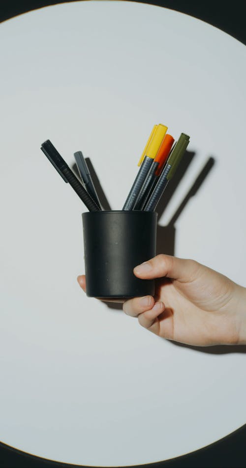 Person Holding Color Pencils in a Container