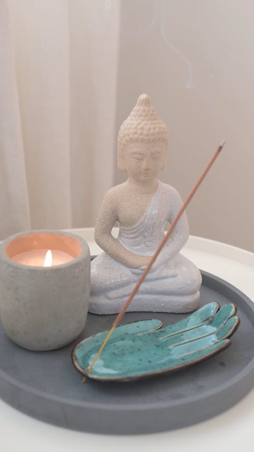 Burning Incense and Candles Beside a Buddha Figurine