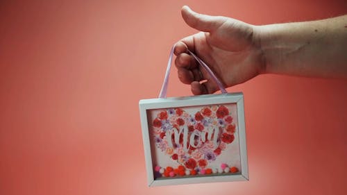 A Person Holding a Mother's Day Themed Frame