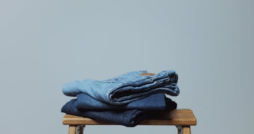 A Pile of Folded Jeans on a Stool