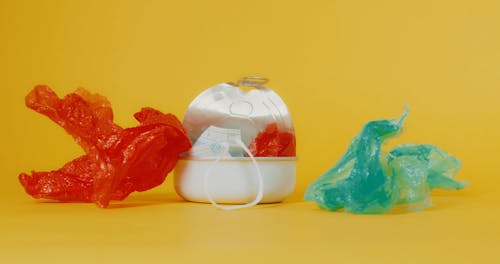 Crumpled Plastics Unfolding beside a Tin Can