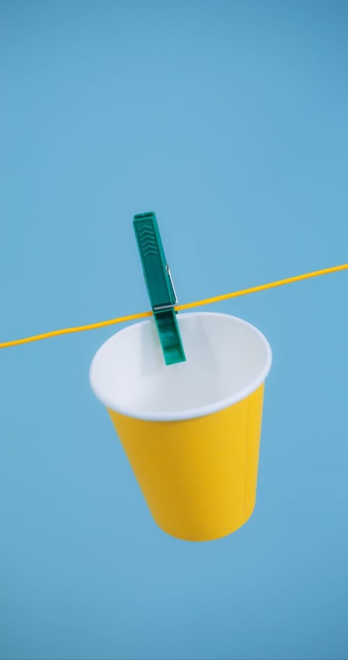 A Yellow Paper Cup Hanging from a Clothesline