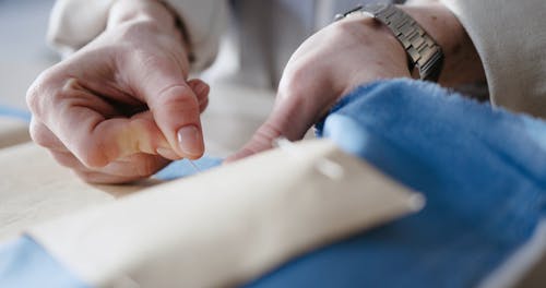 Close up of a Person Pinning a Stencil on Fabric