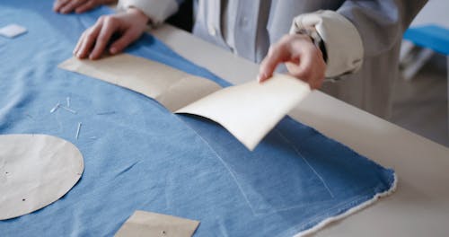 A Person Taking off a Stencil from Fabric