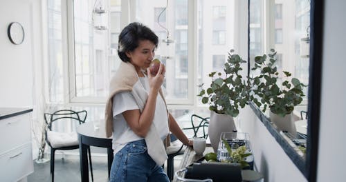 A Young Woman Washing a Mango Fruit