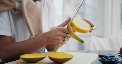 Person Peeling a Mango