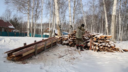 A Man Stacking Pieces of Wood