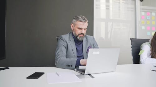 Elderly Man Working while using Laptop