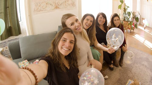 Women Taking Picture while Holding Balloons