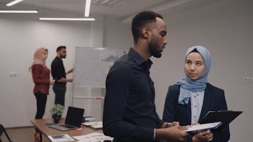 Colleagues Talking while Discussing Reports