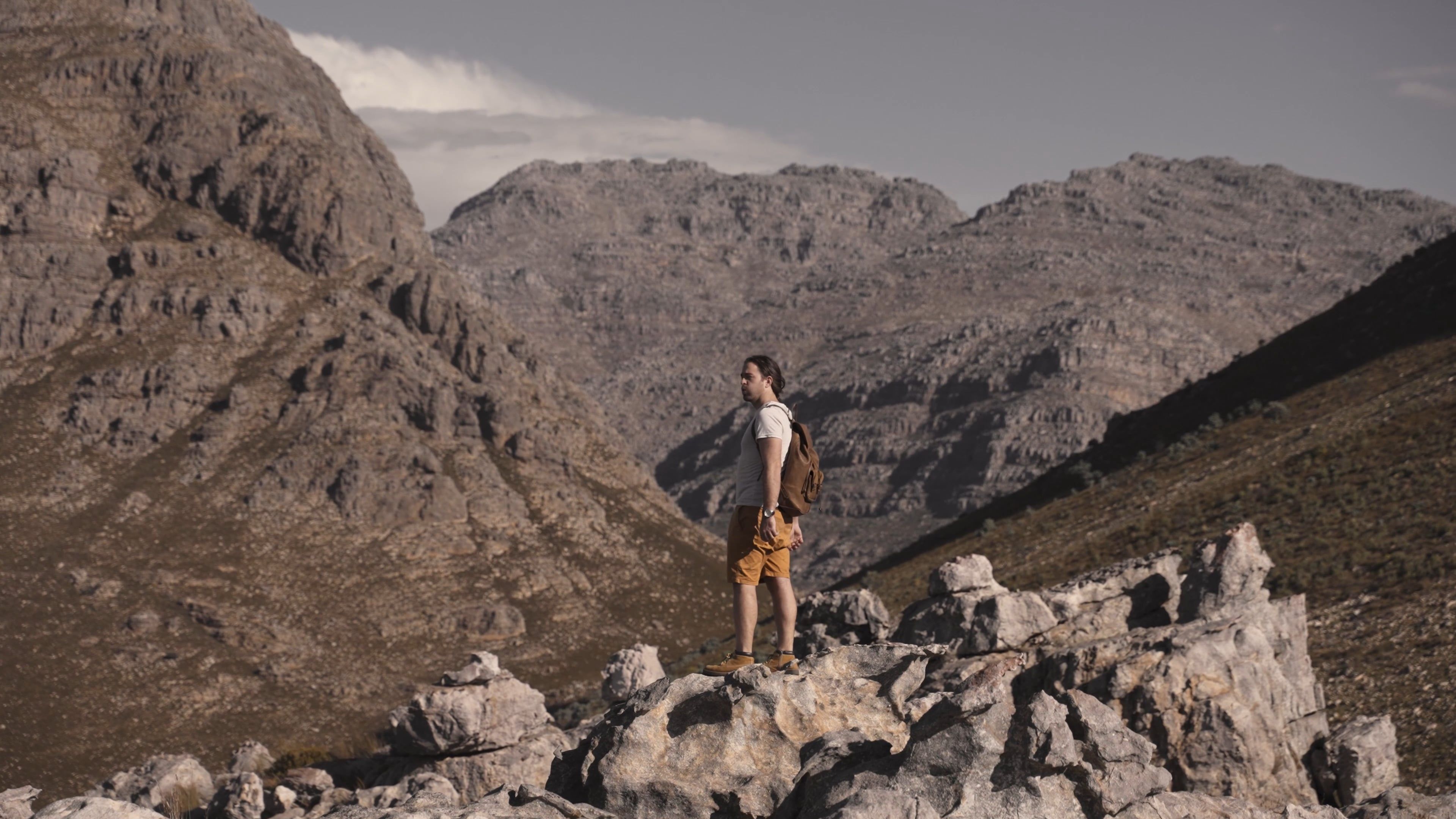 a man standing on rocks feeling excited 7815657