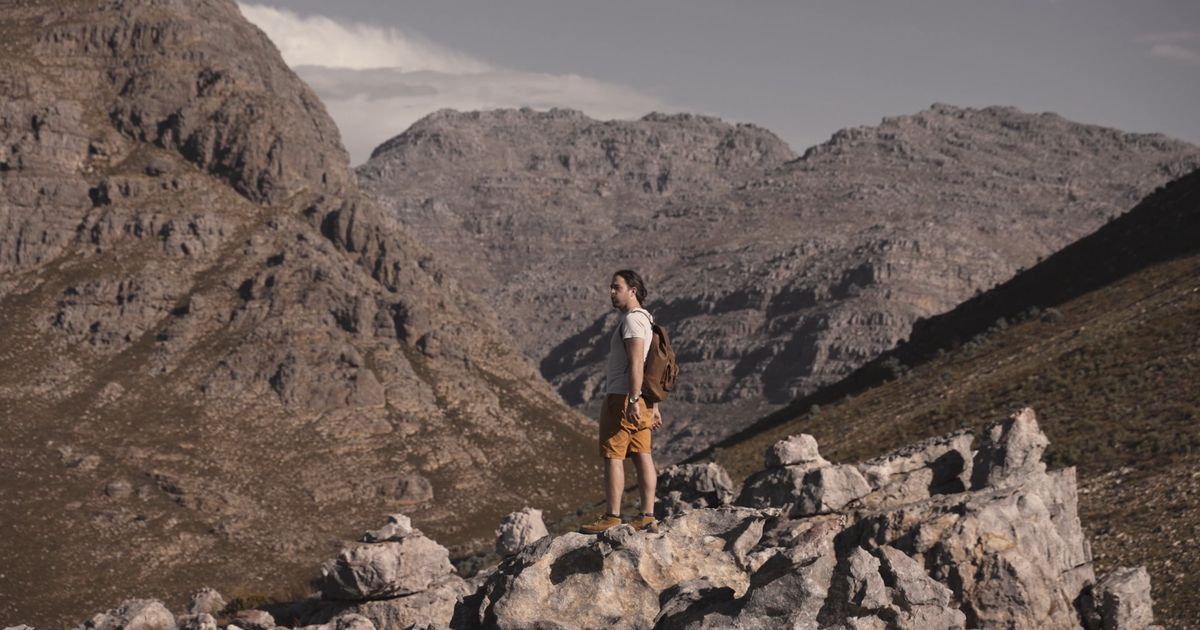 a man standing on rocks feeling excited 7815657