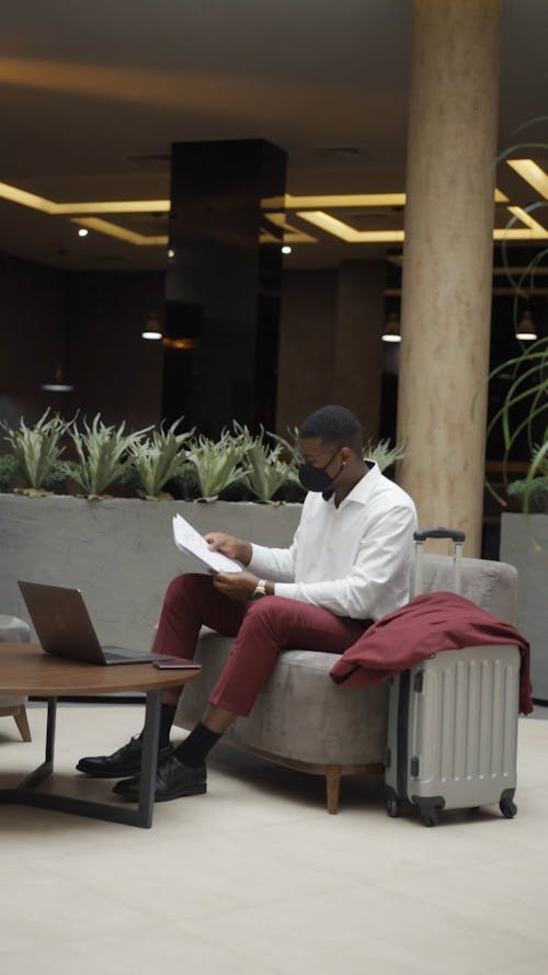 Man Checking on Papers While in a Lobby