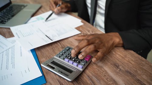 A Man Using a Calculator at Work