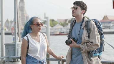 woman wearing sunglasses talking to a man