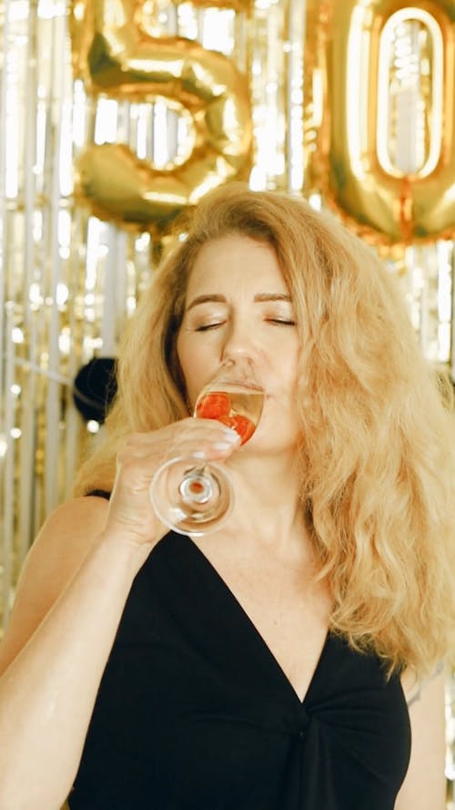 Woman Drinking Wine at a Birthday Party