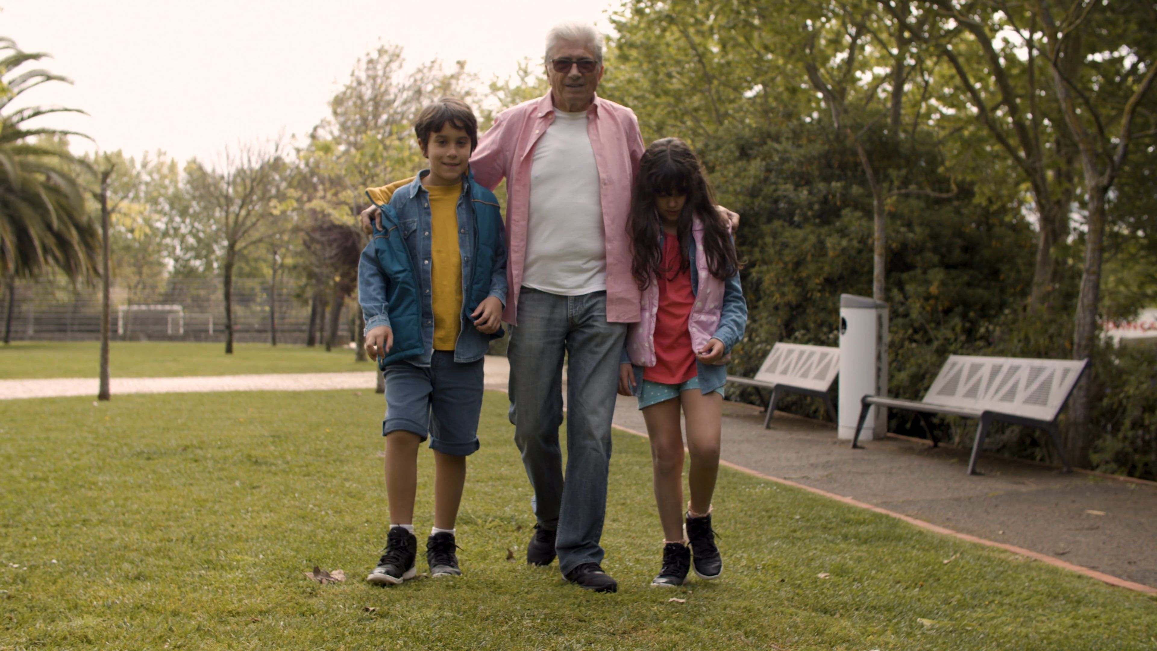 Grand-père marchant dans un parc avec ses deux petits-enfants