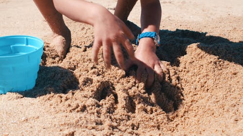 Boy Playing With Sand On a Beach