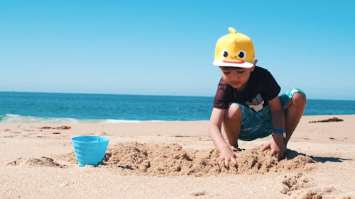 Boy Playing Sand On a Beach