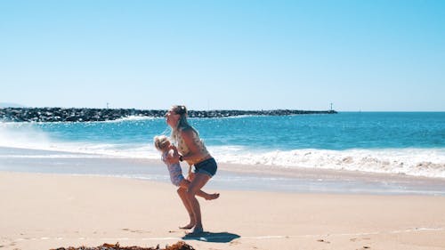 Mother Playing With Her Daughter In the Beach