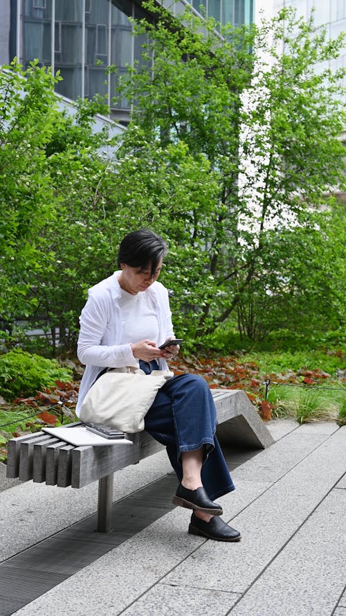 Woman using Smartphone while Sitting on Bench