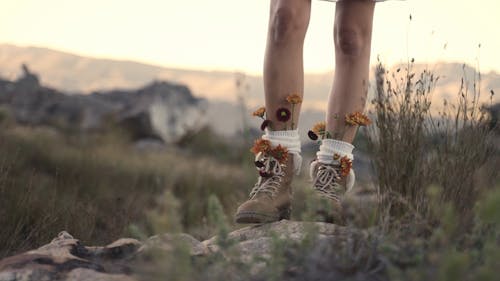 A Person Walking Wearing a Hiking Boots with Flowers
