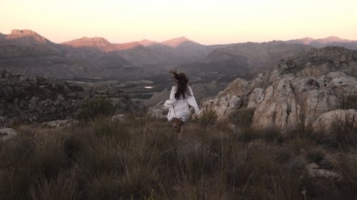 A Woman Running on a Rocky Mountain