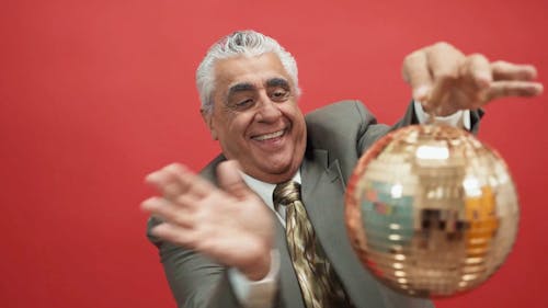 A Happy Man Spinning a Disco Ball