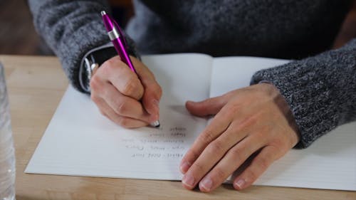 Crop Person Writing With Pen on Paper