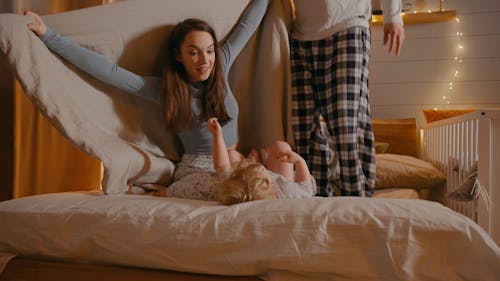 A Family Playing in the Bed at Night Time