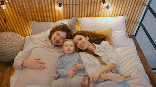 A Family Lying Down on Bed