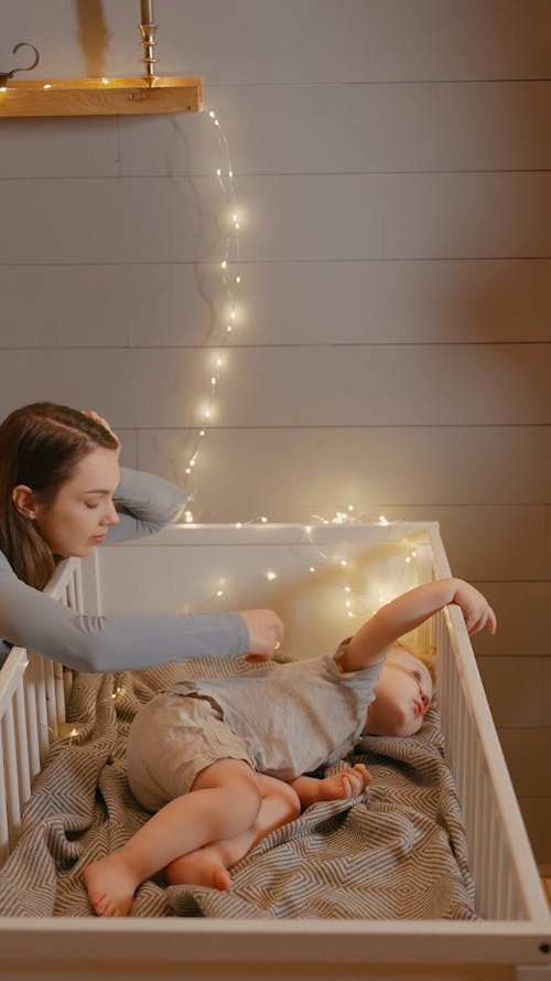 A Woman Caressing his Son in the Crib