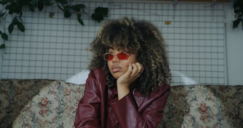 Woman Wearing Leather Jacket Sitting on Sofa