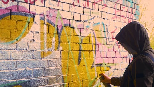Man in a Hoodie Painting a Wall
