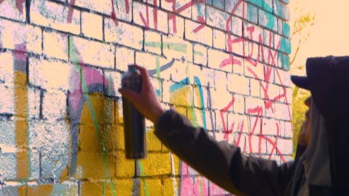 Person Painting A Wall Using Spray