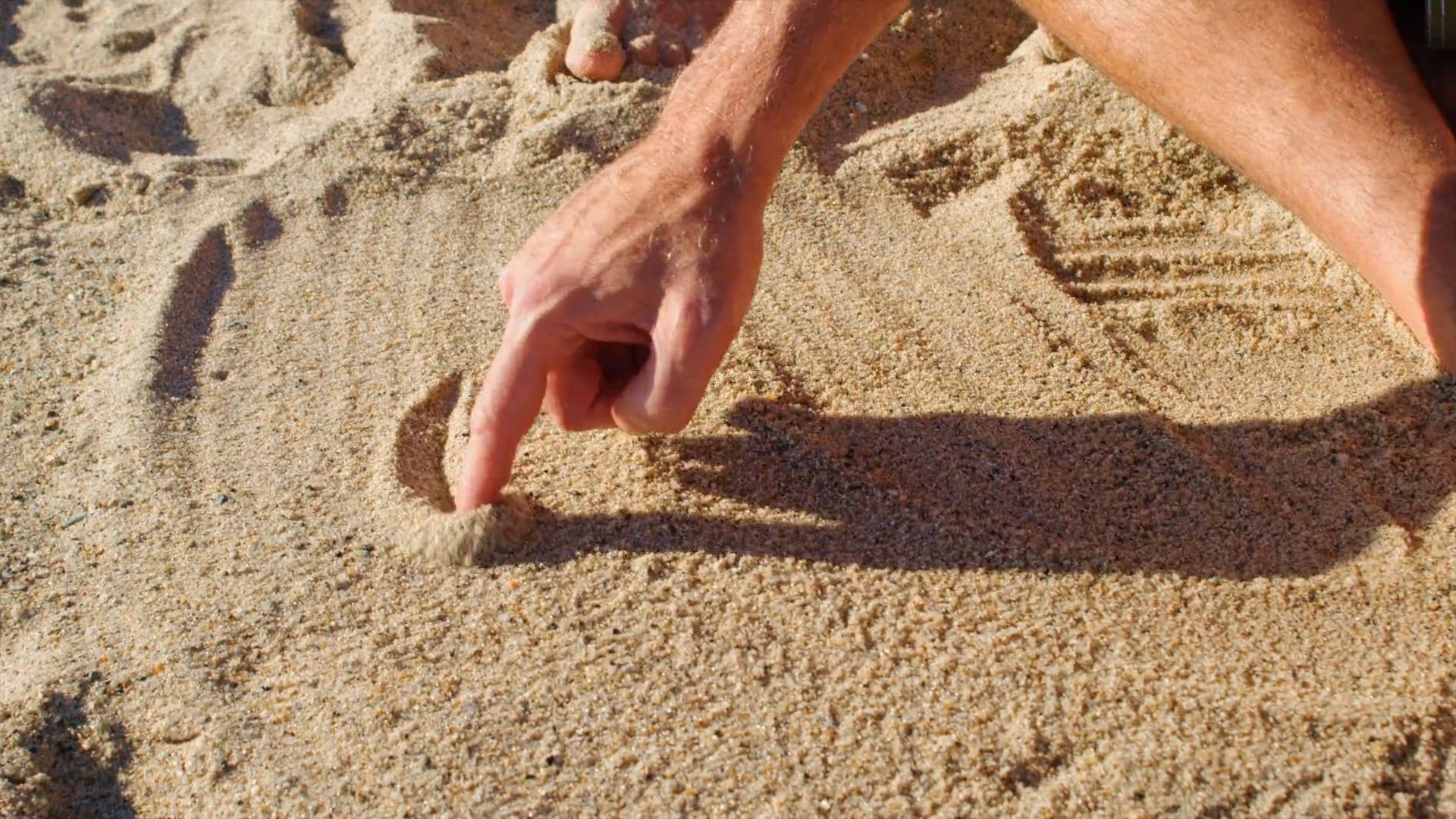 A Man Drawing A Sun In The Sand Free Stock Video a-man-drawing-a-sun-in-the-sand-free-stock-video