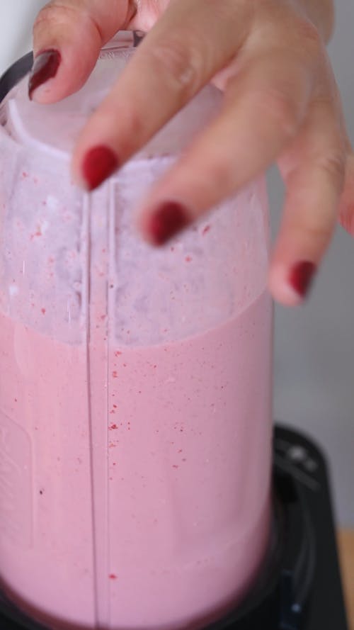 A Person Making a Strawberry Smoothie