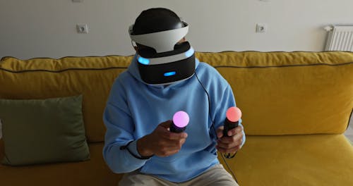 A Person Playing a Video Game Using a VR Headset and Controllers