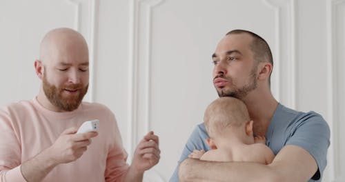 A Man Checking a Temperature of a Baby